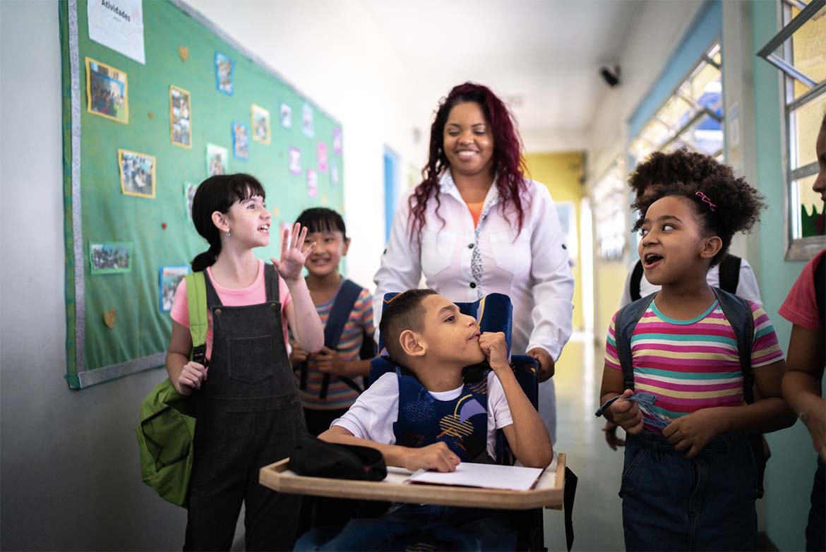 A paraprofessional with the student she's supporting, walking alongside other students.